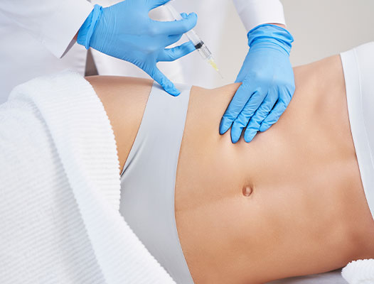 Young woman with a view of plastic surgeon in latex gloves gets lipofilling treatment on her abdomen | Fat transfer